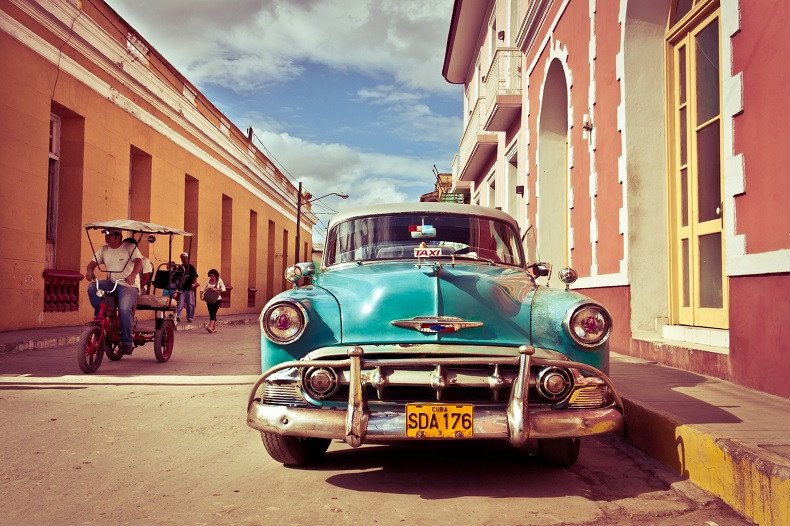 Một du khách đang xem bản đồ và ví tiền, chuẩn bị cho chuyến đi Cuba