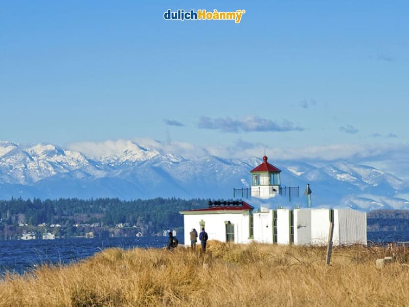 Ngọn hải đăng trong Công viên Discovery Seattle bên bờ biển, tượng trưng cho vẻ đẹp thiên nhiên và điểm đến du lịch, yếu tố thu hút du khách và phát triển kinh tế bền vững.