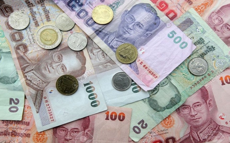 Du khách đang tìm hiểu thông tin về quy định đổi tiền Baht Thái.